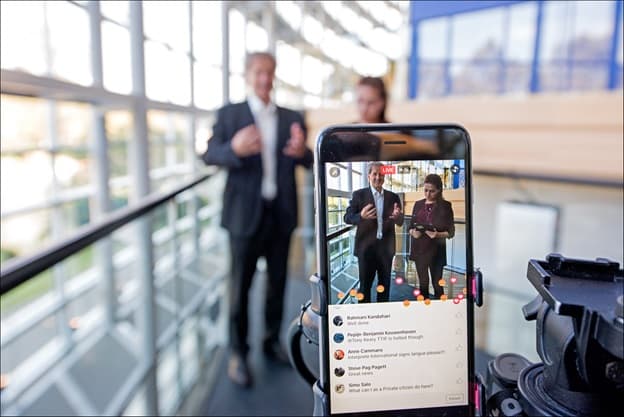 A man and a woman live streaming on Facebook