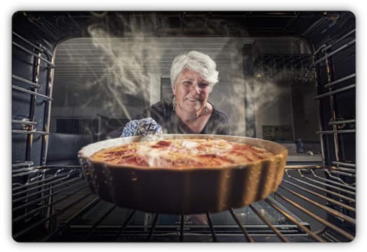 A woman baking a steaming hot cake