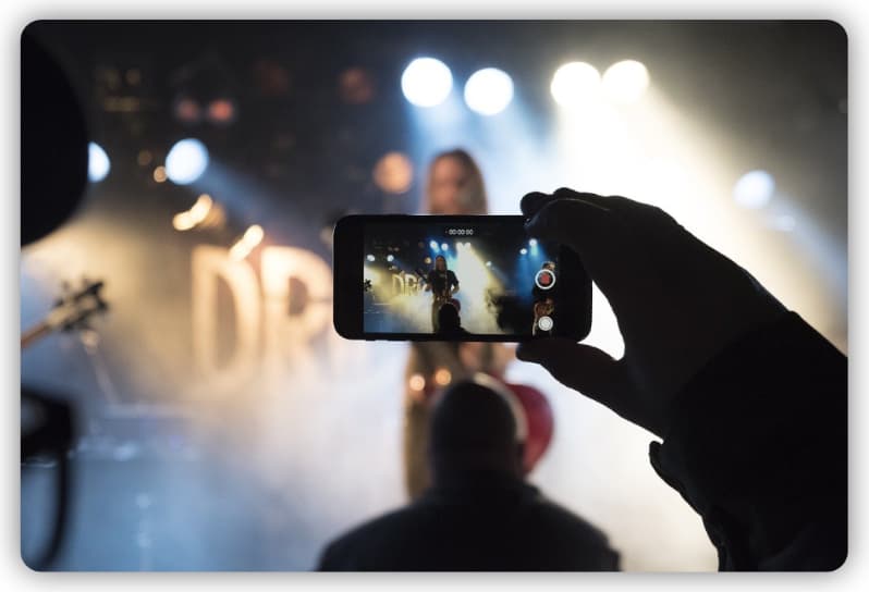 A person recording a live concert on a smartphone