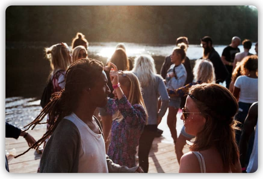 A group of people meeting and celebrating by the riverside