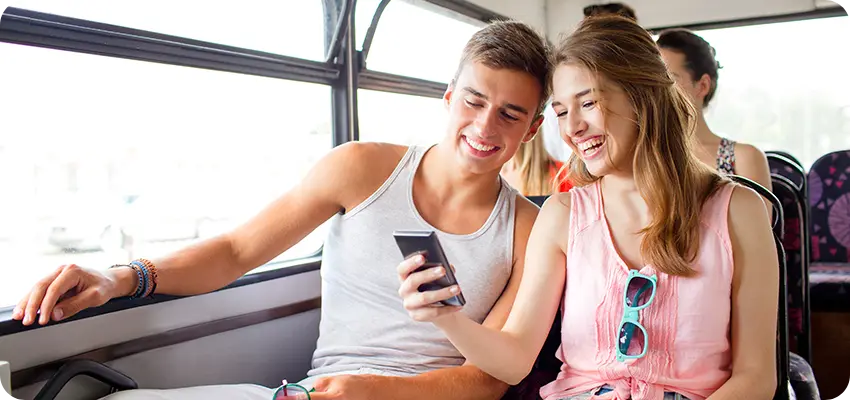 A enjoying a video on a smartphone during bus travel